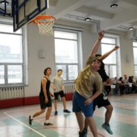 Uczniowie w intensywnej grze koszykówki 2x2 podczas emocjonującego turnieju.